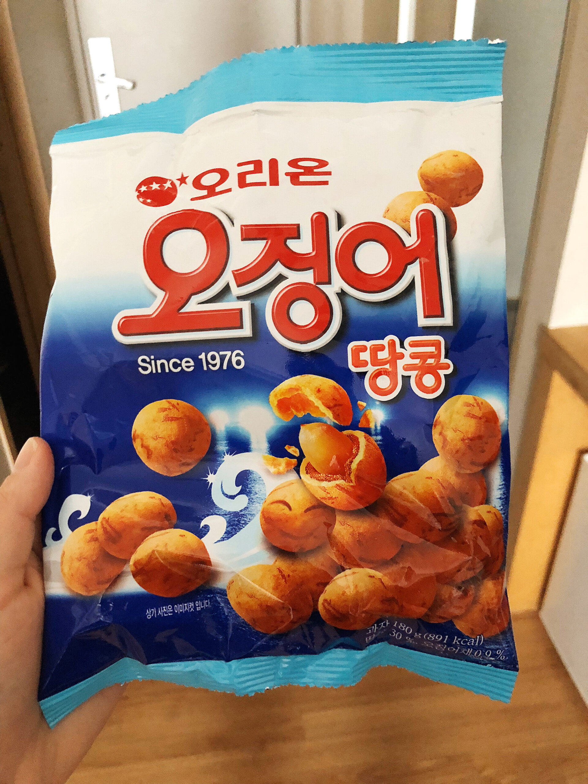 A package of Orian Peanut Balls that are squid flavors being held up