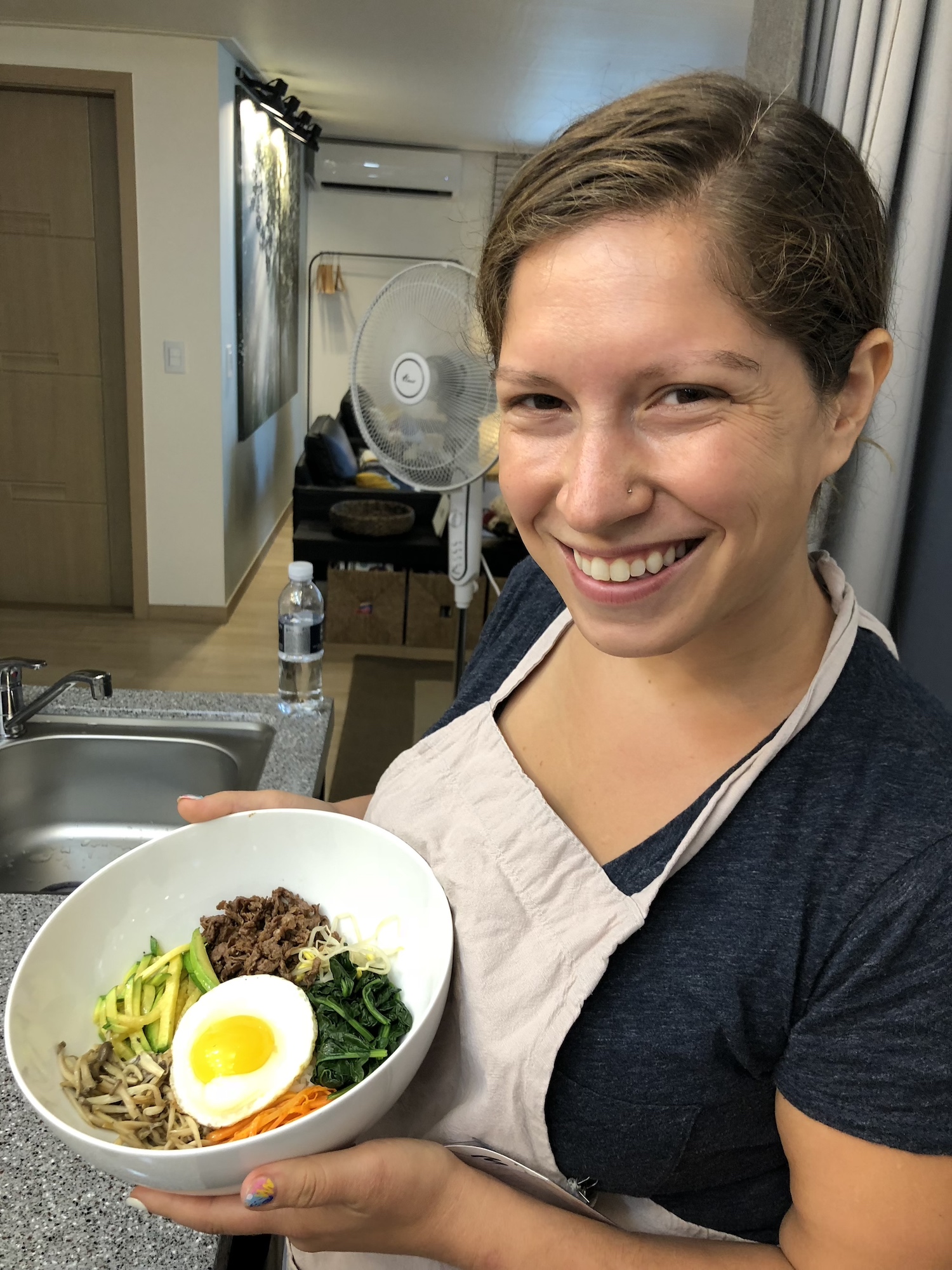 Mattie showing the bibimbap she made at Kcookingclass in Seoul