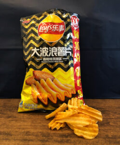 Bag of Lay's Roasted Chicken Wing Flavor Chips with a few chips in front