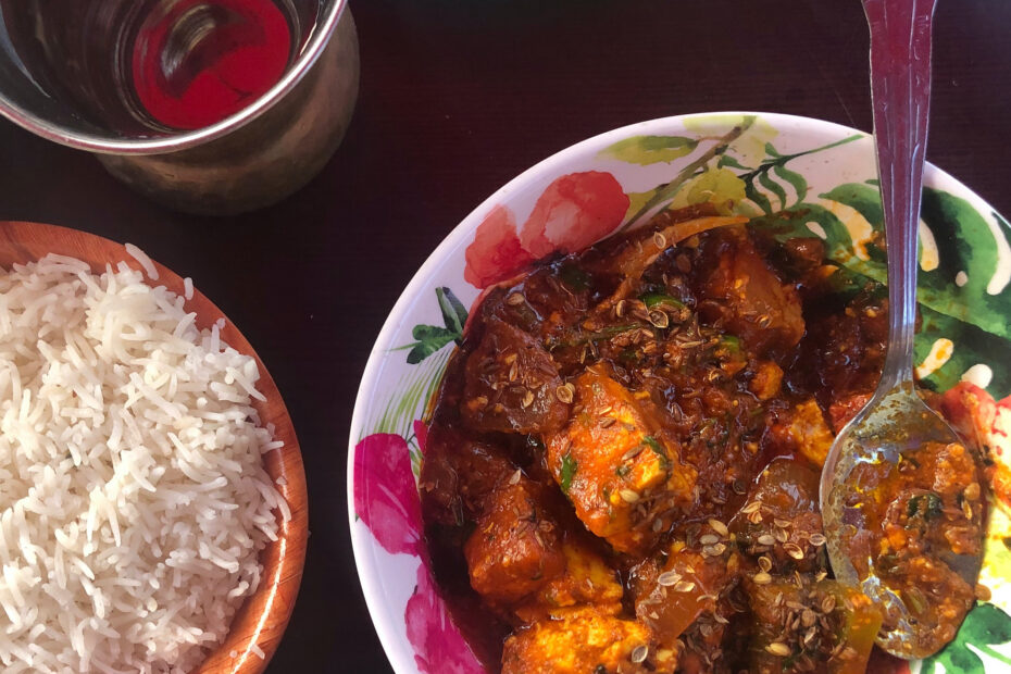 Paneer Khurchan, rice and a cup of water on a table at Angel Indian Restaurant