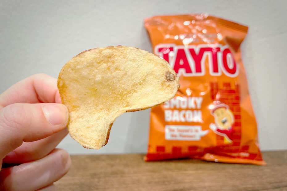 Close-up of a Tayto Smoky Bacon Crisps with a bag blurred in the background