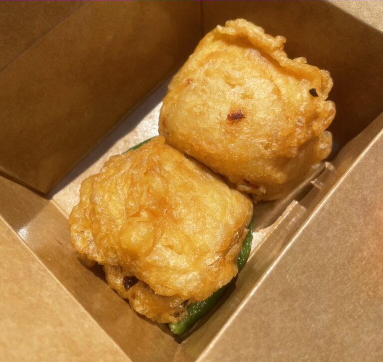 2 Indonesian deep fried tofu balls in a cardboard takeout container