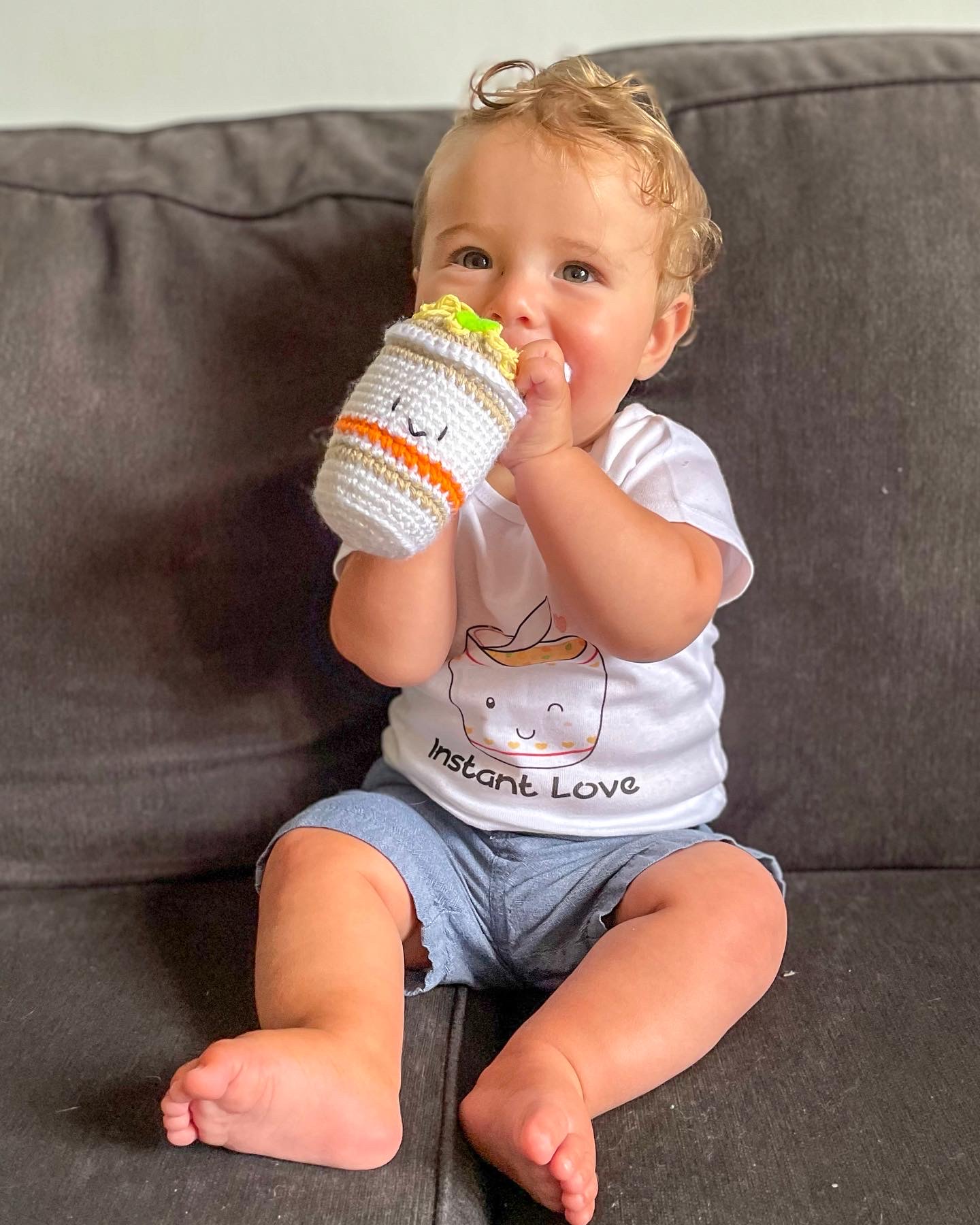 Baby holding an instant noodle shaped rattle with a onesie that says Instant Love from Avery & Me