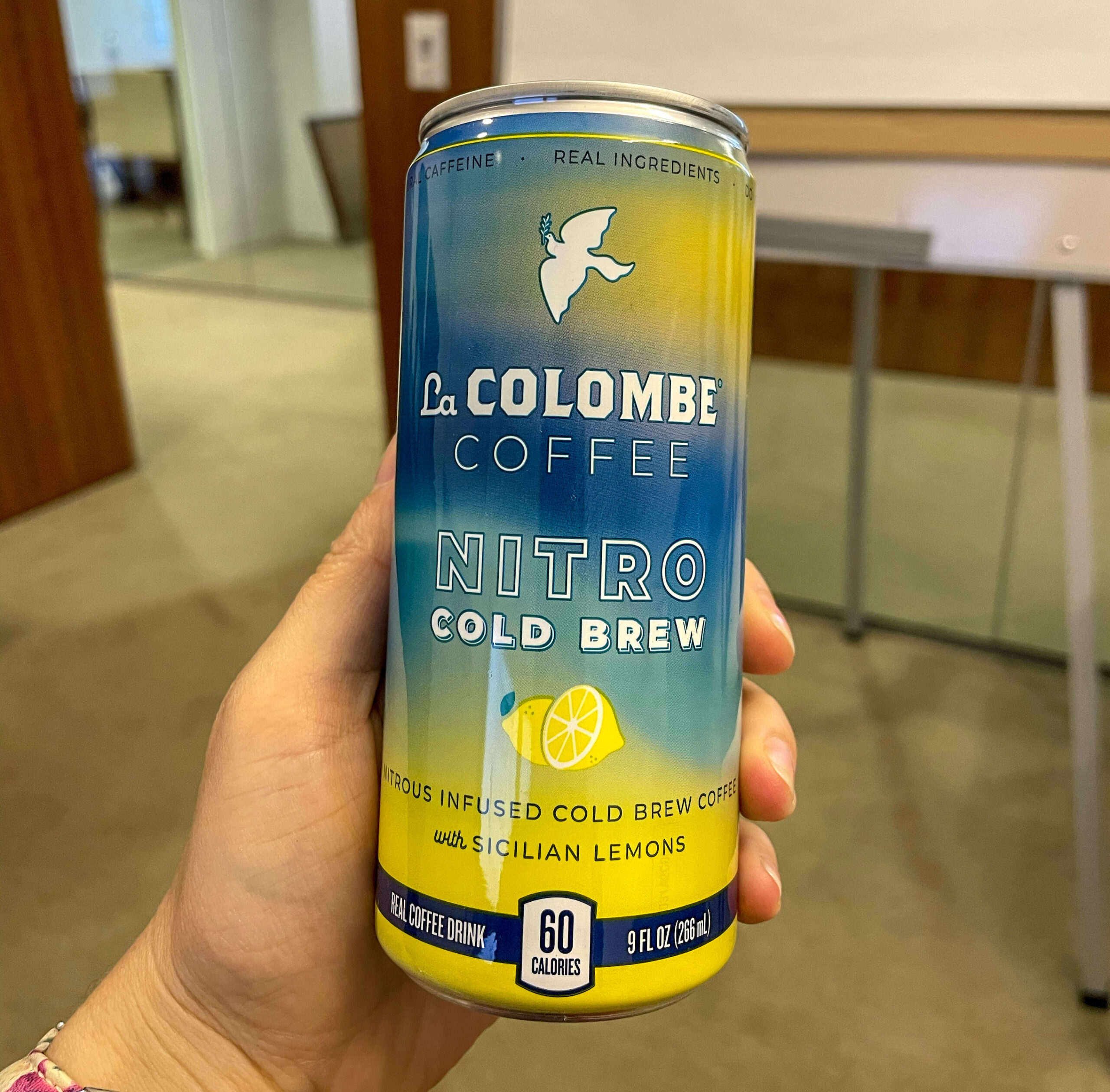A hand holding a can of La Colombe Lemon Nitro Brew