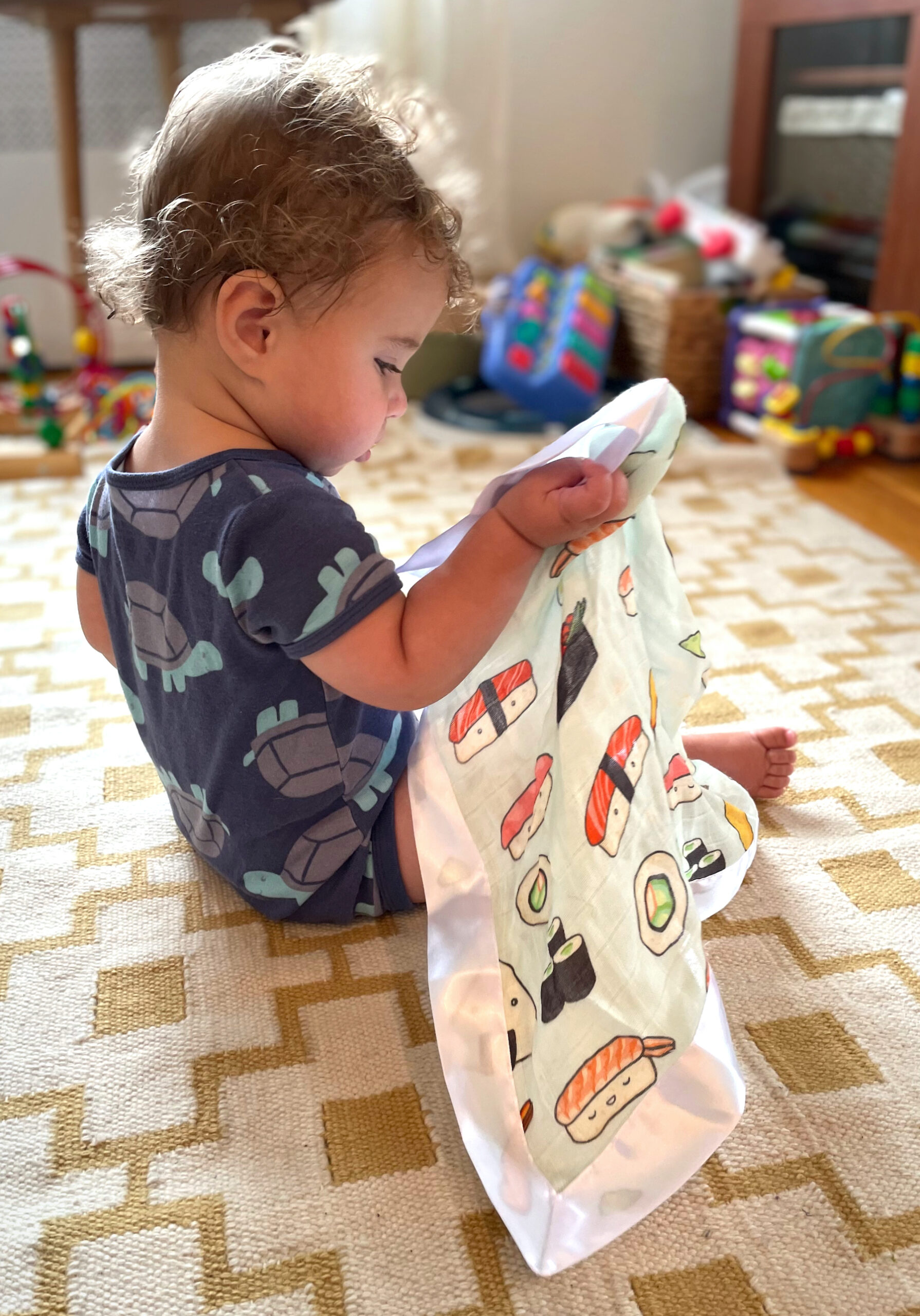 LOULOU LOLLIPOP Sushi Blanket being played with by a baby