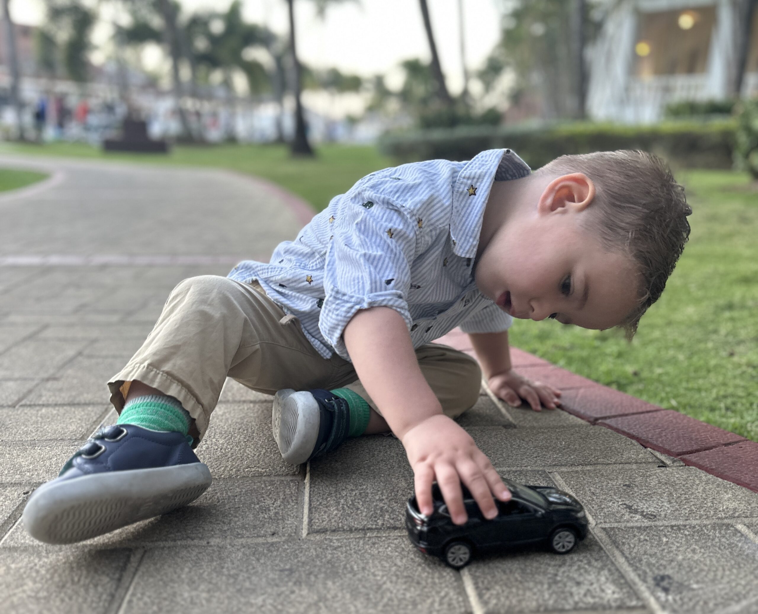 Child playing with a car wearing nice clothing at a resort in Jamaica